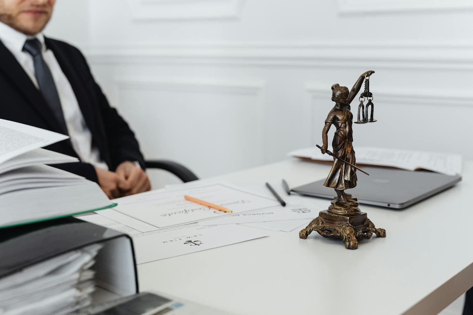 Legal professional desk with Lady Justice statue and court documents